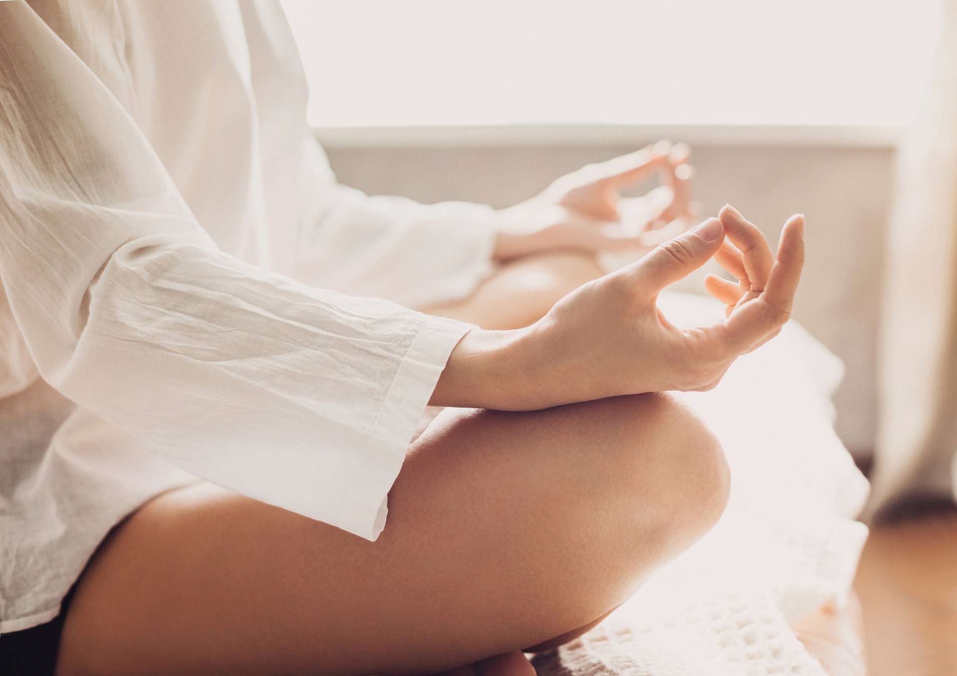 Hands of young beautiful woman practicing yoga at home